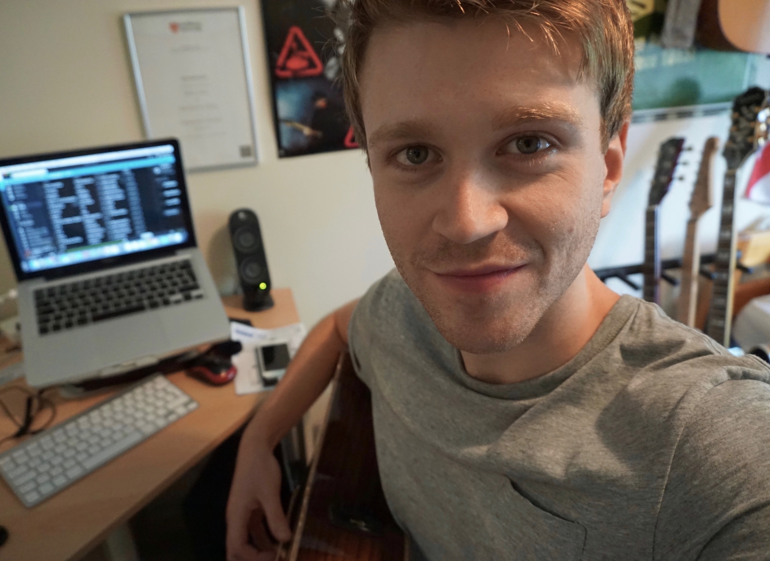 Richard Hunt sat at a desk, holding a guitar.