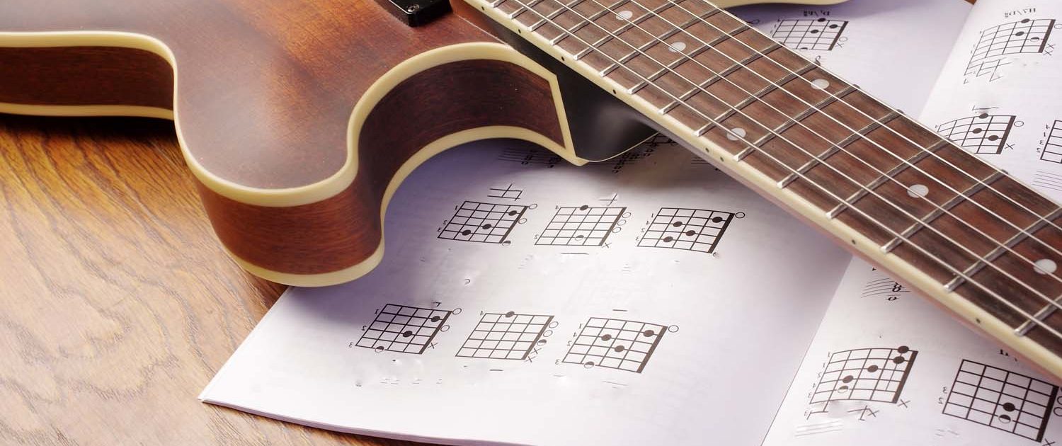 guitar lying on a guitar music book