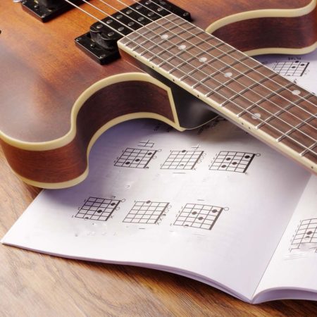 guitar lying on a guitar music book