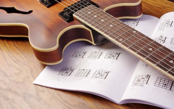 guitar lying on a guitar music book